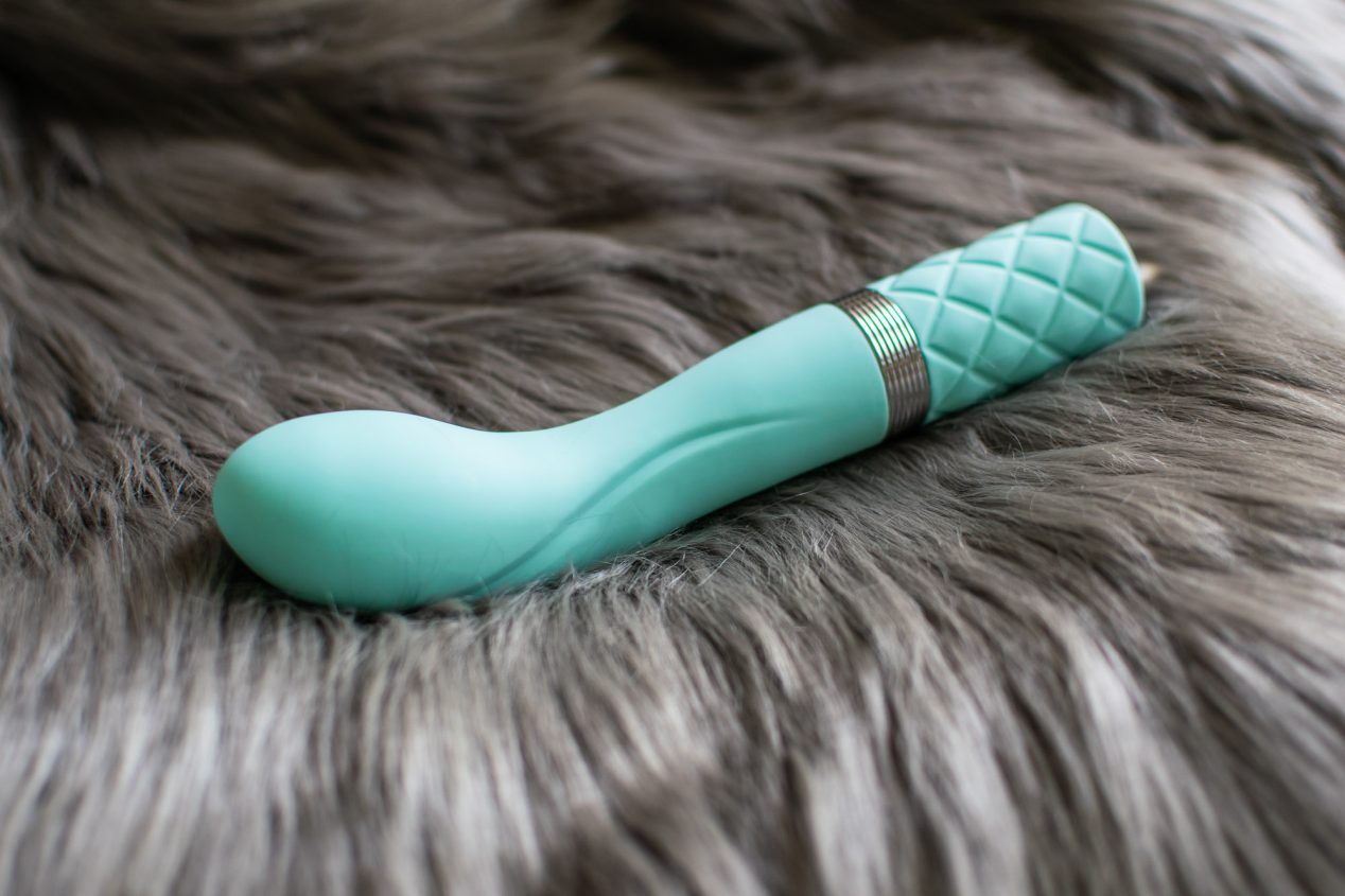 BMS Factory Pillow Talk Sassy rechargeable G-spot vibrator lying on some soft grey fur.