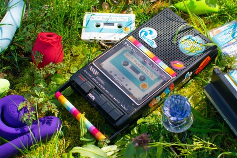 Sex blogger field notes: audio journal. Cassette player lying in the grass, surrounded by sex toys and Epiphora-labeled cassette tapes.