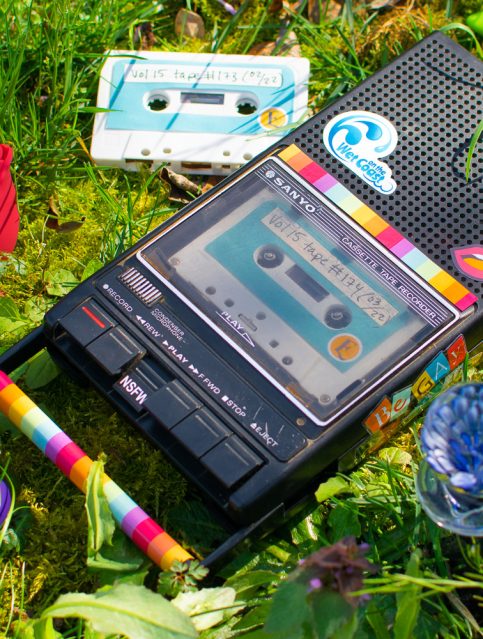 Sex blogger field notes: audio journal. Cassette player lying in the grass, surrounded by sex toys and Epiphora-labeled cassette tapes.