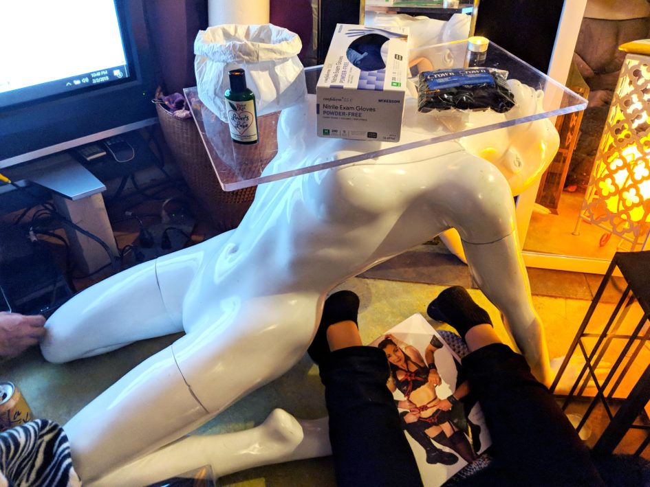 A very unique table: a naked white mannequin doing a backbend, holding a glass surface on its nipples.