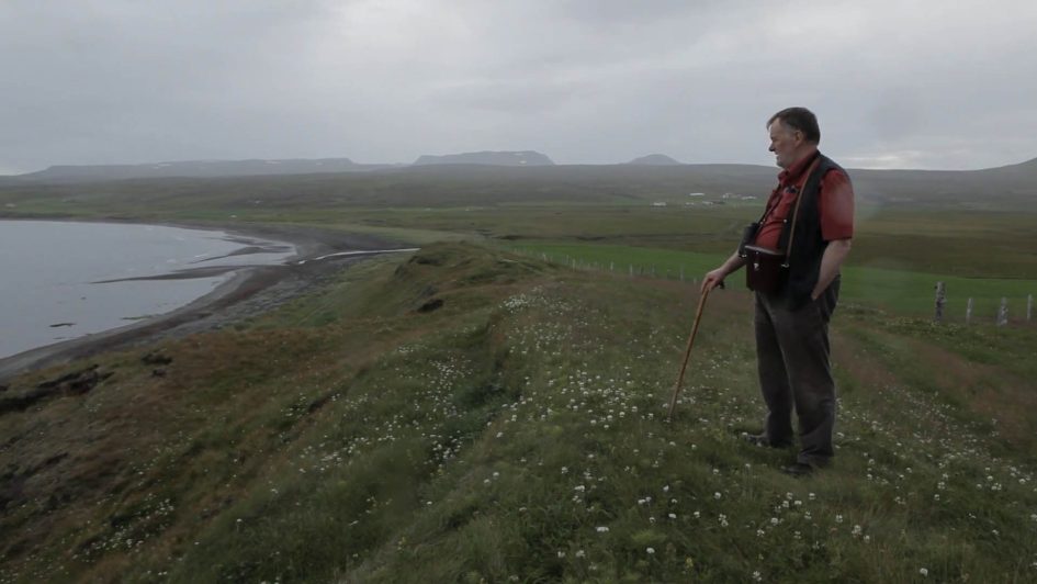 Siggi on the dreary, grey Icelandic countryside, gazing into the distance.