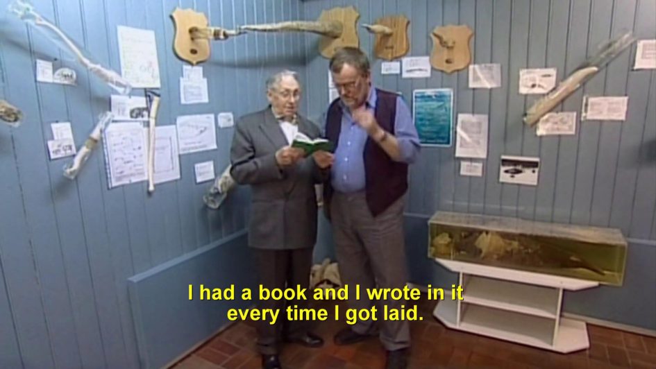 Páll Arason showing Siggi a book. Caption reads: "I had a book and I wrote in it every time I got laid."