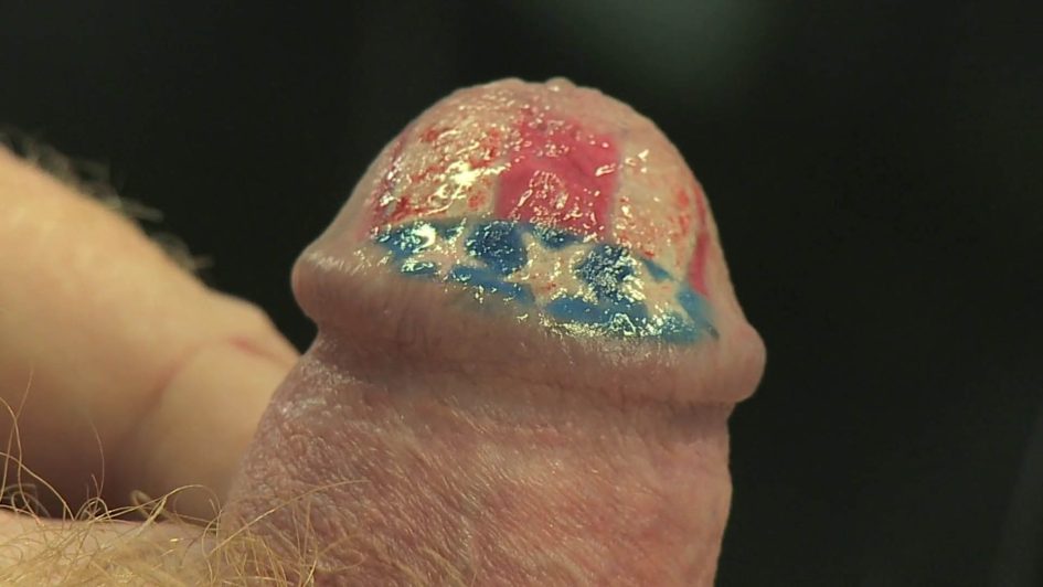 A horrifying close-up of the head of Tom's penis, now tattooed with an American flag design.