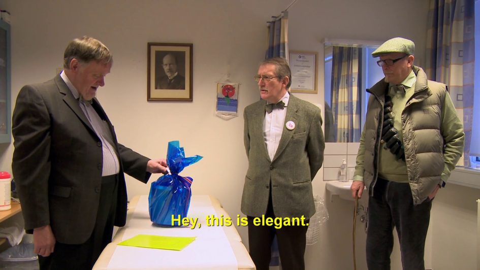 Siggi and his brother and cousin in a hospital room with a bucket wrapped in blue cellophane. Caption reads: "hey, this is elegant."