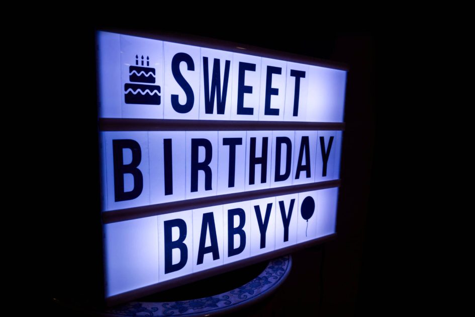 A marquee-style lightbox glowing in the dark. It reads "SWEET BIRTHDAY BABYY."